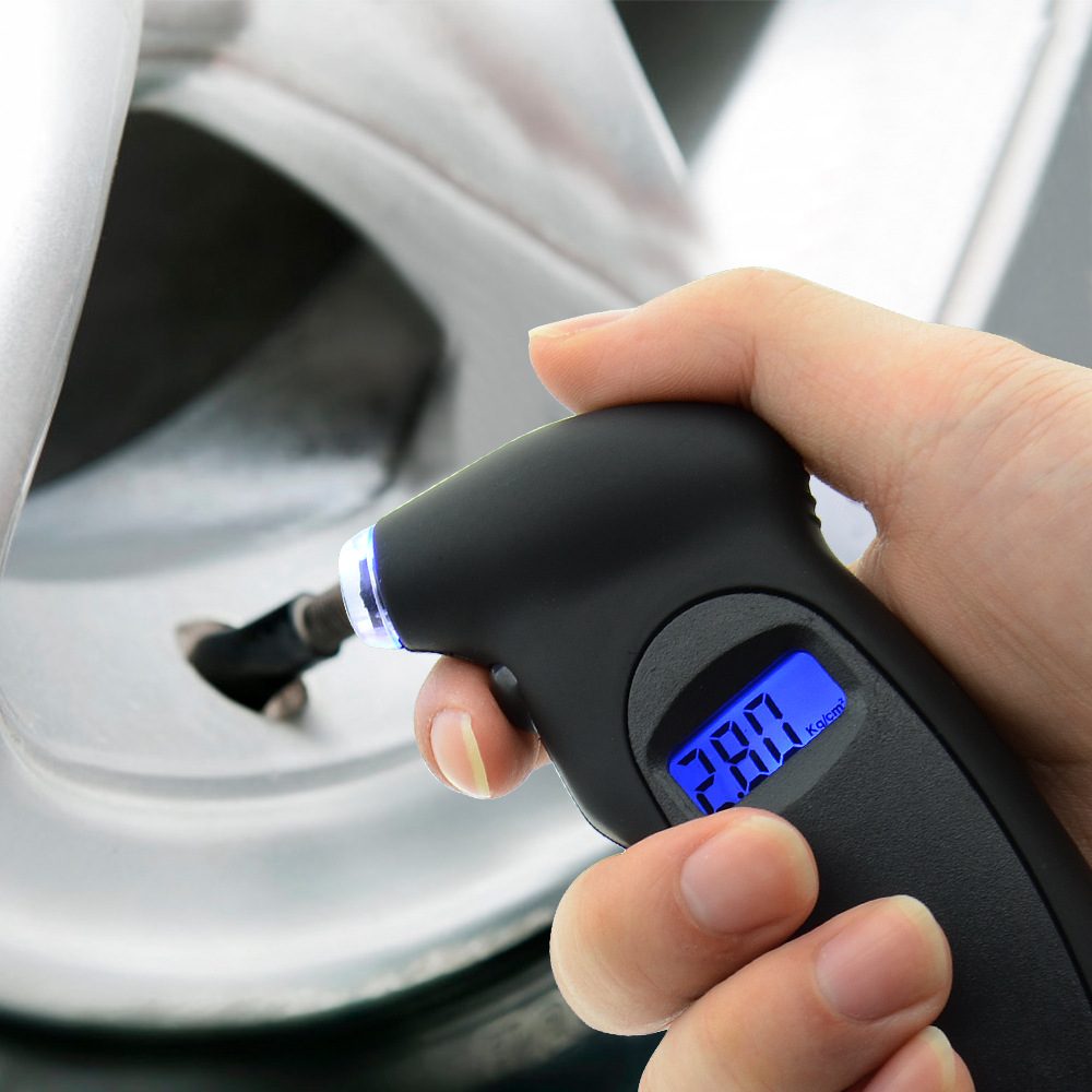 Backlit digital tire gauge checking a car tire valve