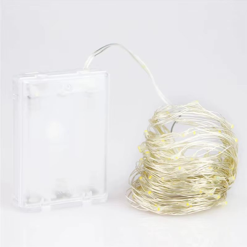 Coiled silver-wire fairy lights with warm-white LEDs next to the clear AA battery box